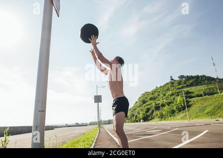 Exercices de poids corporel d'entraînement en utilisant le ballon de poids lourd. Banque D'Images