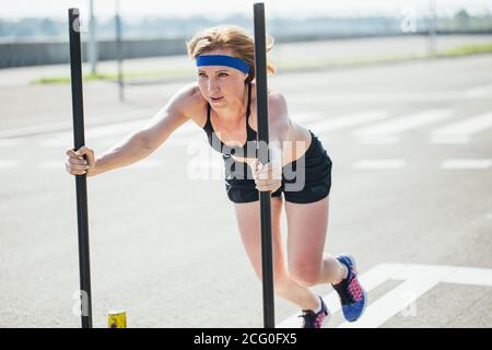 femme poussant l'équipement d'exercice de prowler. Faites de la musculation à la salle de sport Cross Fit Gym Banque D'Images