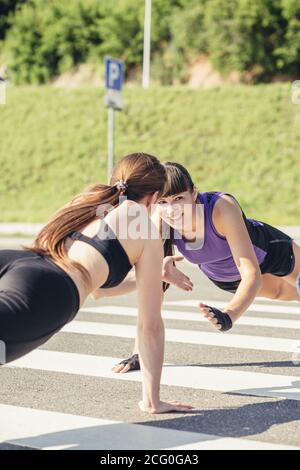 Groupe d'adultes effectuant des exercices physiques à l'extérieur salle d'entraînement physique polyvalente avec lumière vive elles Banque D'Images
