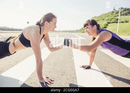 Groupe d'adultes effectuant des exercices physiques à l'extérieur salle d'entraînement physique polyvalente avec lumière vive elles Banque D'Images