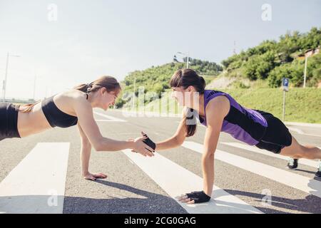 Groupe d'adultes effectuant des exercices physiques à l'extérieur salle d'entraînement physique polyvalente avec lumière vive elles Banque D'Images