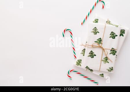 Composition de Noël. Cadeaux, bonbons de Noël rouge et vert, décorations sur fond blanc. Le concept de Noël, hiver, nouvel an. Plat Banque D'Images