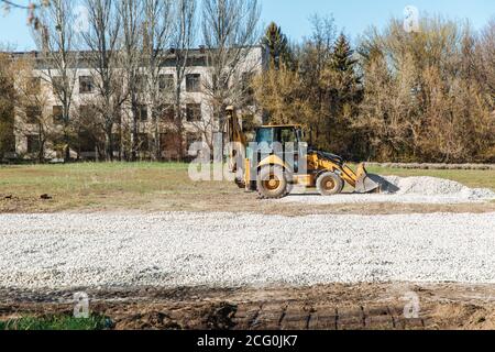 Dnepro-culudnoe/Ukraine - avril 08 2020 : un tracteur verse le gravier du godet Banque D'Images