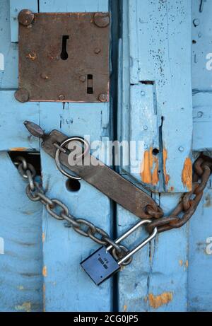 Des chaînes et des serrures sécurisent une porte en bois d'époque d'un magasin fermé à Santa Fe, Nouveau-Mexique. Banque D'Images