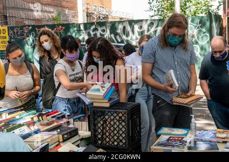 Les amateurs de livres affluent dans le quartier Astoria de Queens à New York le dimanche 30 août 2020 pour parcourir les livres donnés gratuitement lors d'une foire du livre. (© Richard B. Levine) Banque D'Images