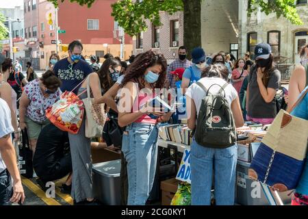 Les amateurs de livres affluent dans le quartier Astoria de Queens à New York le dimanche 30 août 2020 pour parcourir les livres donnés gratuitement lors d'une foire du livre. (© Richard B. Levine) Banque D'Images