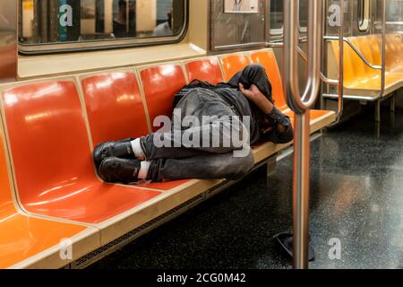 Un homme sans domicile dort dans un métro à New York le dimanche 30 août 2020. (© Richard B. Levine) Banque D'Images