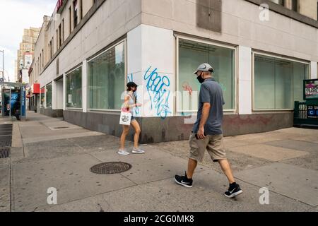 Les gens marchent devant une vitrine vacante, autrefois occupée par The Gap, dans le quartier de Chelsea à New York le lundi 24 août 2020 ( © Richard B. Levine) Banque D'Images