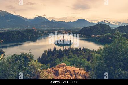 Vue panoramique sur le lac de Bled avec l'île et l'église au coucher du soleil avec les alpes en arrière-plan, Slovénie, Europe Banque D'Images