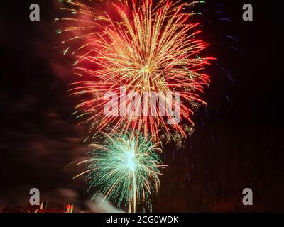 Deux feux d'artifice aux teintes rouges et turquoise Banque D'Images