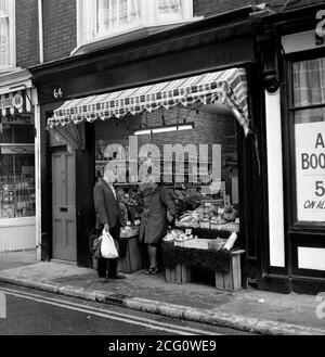 AJAXNETPHOTO. 1975. SOUTHSEA, ANGLETERRE. - TEMPS POUR UNE DISCUSSION - ROUTE DU CHÂTEAU FRAIS MAGASIN DE LÉGUMES PROPRIÉTAIRE ET CLIENT. PHOTO:JONATHAN EASTLAND/AJAX REF:750081 087 Banque D'Images