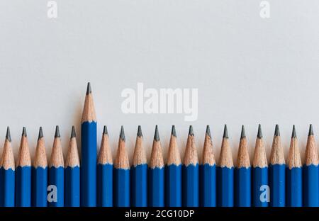 Rangée de dessus de nombreux nouveaux crayons bleus aiguisés contre papier blanc. Banque D'Images