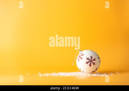 Boule de Noël. Fond de Noël avec ornements blancs et rouges sur jaune. Carte de vœux de joyeux noël. Hiver vacances thème Noël. Bonne Année. Banque D'Images