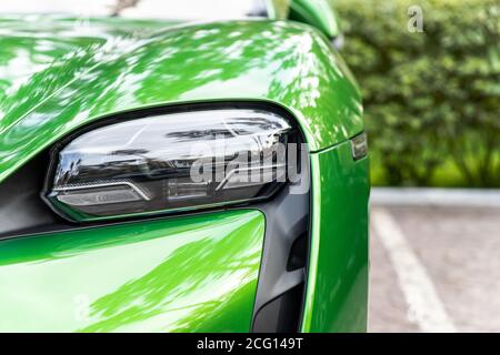 Gros plan de luxe vert brillant SPAR supercar véhicule matrice système LED projecteur détail garé dans la rue à l'extérieur de la ville. Avant de voiture électrique Banque D'Images