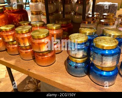 Piles de bougies en pot colorées à vendre dans un magasin de détail. Banque D'Images