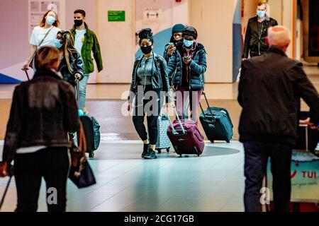 Les voyageurs portant des masques de protection contre la propagation du covid 19.l'aéroport de Schiphol est occupé à nouveau à opérer sous des mesures, KLM reçoit un paquet de soutien de 3.4 milliards d'euros pour survivre à la crise du coronavirus. Banque D'Images