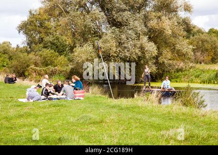 Les personnes et les familles apprécient le soleil d'été pique-nique et punting Les rives de la rivière Cam à Grantchester Meadows Cambridge Cambridgeshire Banque D'Images