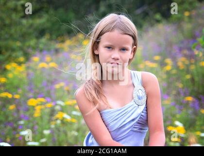 Jeune fille Blonde dans un champ de fleurs Banque D'Images