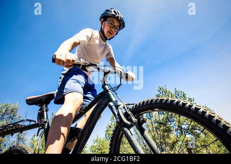 Un jeune garçon fait son vélo tout terrain sur un sentier dans le nord de l'Idaho. Banque D'Images