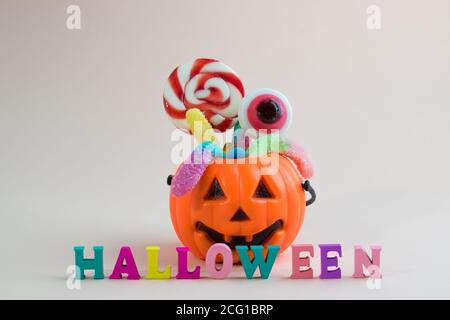 Panier avec bonbons et l'inscription Halloween sur un doux arrière-plan avec espace pour le texte Banque D'Images
