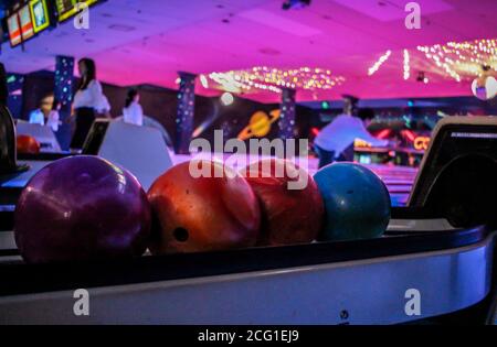 Boules de bowling à l'intérieur d'une piste de bowling sombre et éclairée au néon Banque D'Images