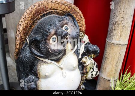 Statue de Tanuki devant une entreprise au Japon Banque D'Images