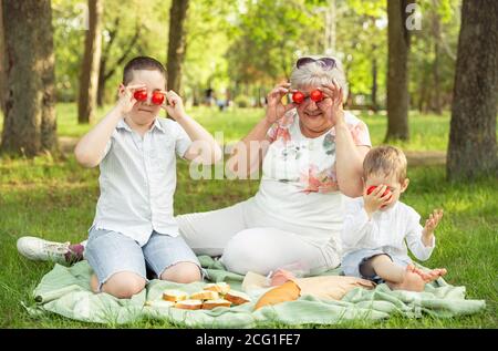 Granny et les petits-fils se bertent, mettant des tomates au lieu des yeux Banque D'Images