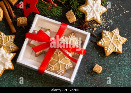 Cuisson de Noël. Biscuits maison au pain d'épice dans une boîte cadeau sur fond de pierre ou d'ardoise. Banque D'Images
