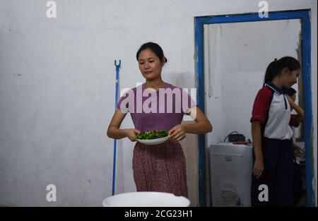 (200909) -- GUANGZHOU, le 9 septembre 2020 (Xinhua) -- Lin Xiaolian (L) cuisine de la nourriture après le travail dans son dortoir de l'île Beili dans le comté de Xuwen, dans la province de Guangdong, au sud de la Chine, le 1er septembre 2020. Il y a six ans, Lin Xiaolian est venu sur cette île comme professeur bénévole après avoir obtenu son diplôme de l'Université normale de Lingnan à Guangdong. Et puis elle a choisi de rester ici pour être enseignante. Le village insulaire de Beili, isolé et pauvre, ne voit guère d'étrangers. Il n'y a pas de restaurants, d'hôtels ni de voitures sur l'île, couvrant seulement 7 kilomètres carrés. L'école primaire de Beili compte plus de 300 élèves, mais est staf Banque D'Images