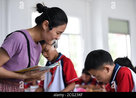 (200909) -- GUANGZHOU, le 9 septembre 2020 (Xinhua) -- Lin Xiaolian donne une leçon d'anglais aux élèves de sixième année à l'école primaire Beili de l'île Beili, dans le comté de Xuwen, dans la province de Guangdong, dans le sud de la Chine, le 1er septembre 2020. Il y a six ans, Lin Xiaolian est venu sur cette île comme professeur bénévole après avoir obtenu son diplôme de l'Université normale de Lingnan à Guangdong. Et puis elle a choisi de rester ici pour être enseignante. Le village insulaire de Beili, isolé et pauvre, ne voit guère d'étrangers. Il n'y a pas de restaurants, d'hôtels ni de voitures sur l'île, couvrant seulement 7 kilomètres carrés. L'école primaire de Beili a plus de 300 Banque D'Images