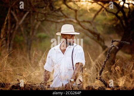 homme africain dans la brousse africaine avec chapeau de brousse l'herbe Banque D'Images