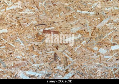 Vue en contreplat sur le fond de placage en bois OSB. Panneaux OSB en copeaux de bois bruns poncés sur fond de bois. Banque D'Images