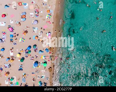 Photographie aérienne de plage, personnes et parasols colorés sur la plage de Seaside Banque D'Images