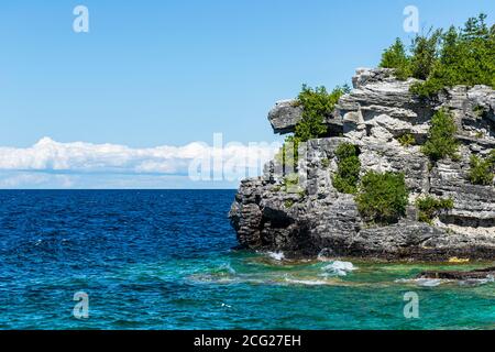 Rochers superposés sur le rivage avec vagues et ciel Banque D'Images