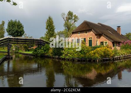 Giethoorn, pays-Bas - 28 août 2020 : maison à toit de chaume rouge derrière le pont en bois Banque D'Images