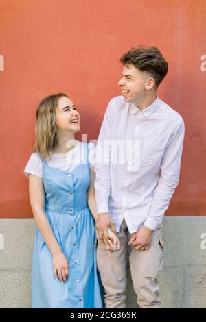 Couple, relations, portrait d'extérieur. Chic hippster heureux couple, gars en chemise blanche et fille en robe bleue, ayant l'amusement à l'extérieur dans la ville Banque D'Images