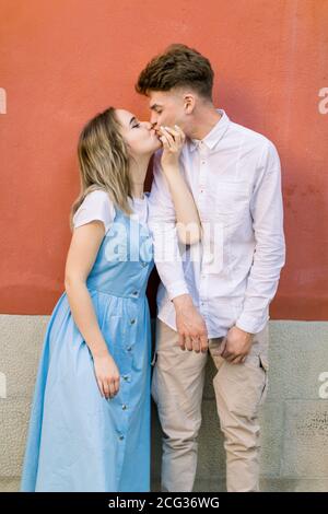 Couple, relations, portrait d'extérieur. Chic hippster heureux couple, gars en chemise blanche et fille en robe bleue, ayant l'amusement à l'extérieur dans la ville Banque D'Images