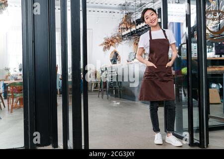 Debout à la porte de la serveuse du café Banque D'Images