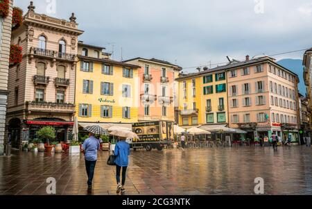 Lugano Suisse , 1er juillet 2020 : personnes avec parasols par jour couvert de pluie sur la place Piazza della Riforma avec des bâtiments colorés à Lugano Tessin Banque D'Images