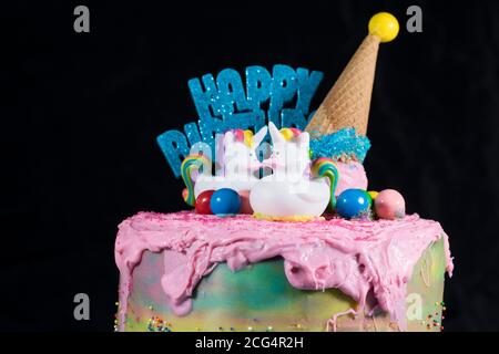 Gâteau d'anniversaire arc-en-ciel coupant une tranche de gâteau gros plan avec un couteau, servant le gâteau à la fête d'anniversaire. Banque D'Images
