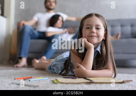 Mignon enfant fille jouant sur le sol, petit enfant d'âge préscolaire dessin avec des crayons de couleur sur le papier passer du temps avec la famille Banque D'Images