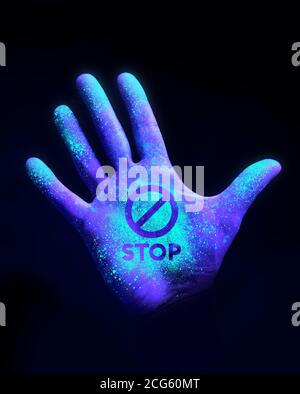 Arrêter la propagation de la défacilité. Une main humaine qui brille à partir de la lumière UV ultra-violette montrant des bactéries et des virus. Laver vos mains concept. Banque D'Images