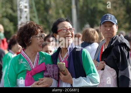 Moscou, Russie, 14 septembre 2019 : deux femmes asiatiques d'âge moyen souriantes portant des lunettes et des costumes brillants au festival chinois de VDNH Banque D'Images