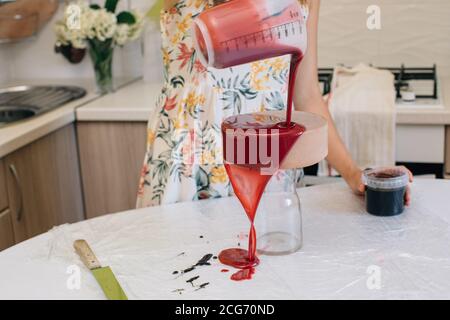 Femme qui délaque un chocolat en velours rouge fait maison gâteau Banque D'Images