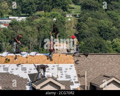 Morgantown, WV - 8 septembre 2020 : entrepreneur en toiture qui retire la fausse cheminée du toit de maison avant de la remplacer par de nouveaux bardeaux Banque D'Images