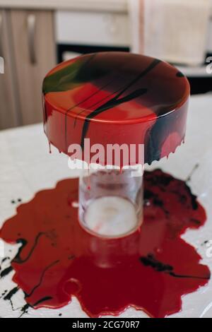 Glaçage séchant sur un chocolat au velours rouge fait maison gâteau Banque D'Images