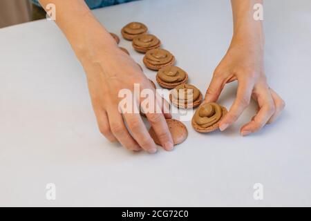 Femme qui fabrique des macarons au chocolat Banque D'Images