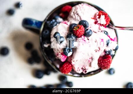 Dessert d'été avec crème glacée, bleuets, framboises et myrtilles Banque D'Images