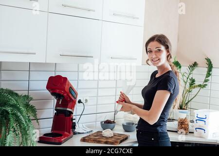 Belle femme pâtissière chef fait des gâteaux sucrées dans la cuisine Banque D'Images