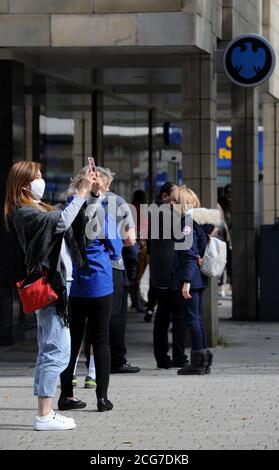 Bolton, Lancashire, 9 septembre 2020. Les habitants de Bolton sont confrontés aujourd'hui à leur première journée complète d'un nouveau verrouillage plus strict. Les pubs, les bars et les restaurants ne sont autorisés qu'à servir un service à emporter, alors qu'il n'est pas permis de rencontrer quelqu'un de l'extérieur de votre famille. Une femme faisant la queue à Barclays Bank prend une photo. Crédit: Paul Heyes/ Alamy Live News Banque D'Images